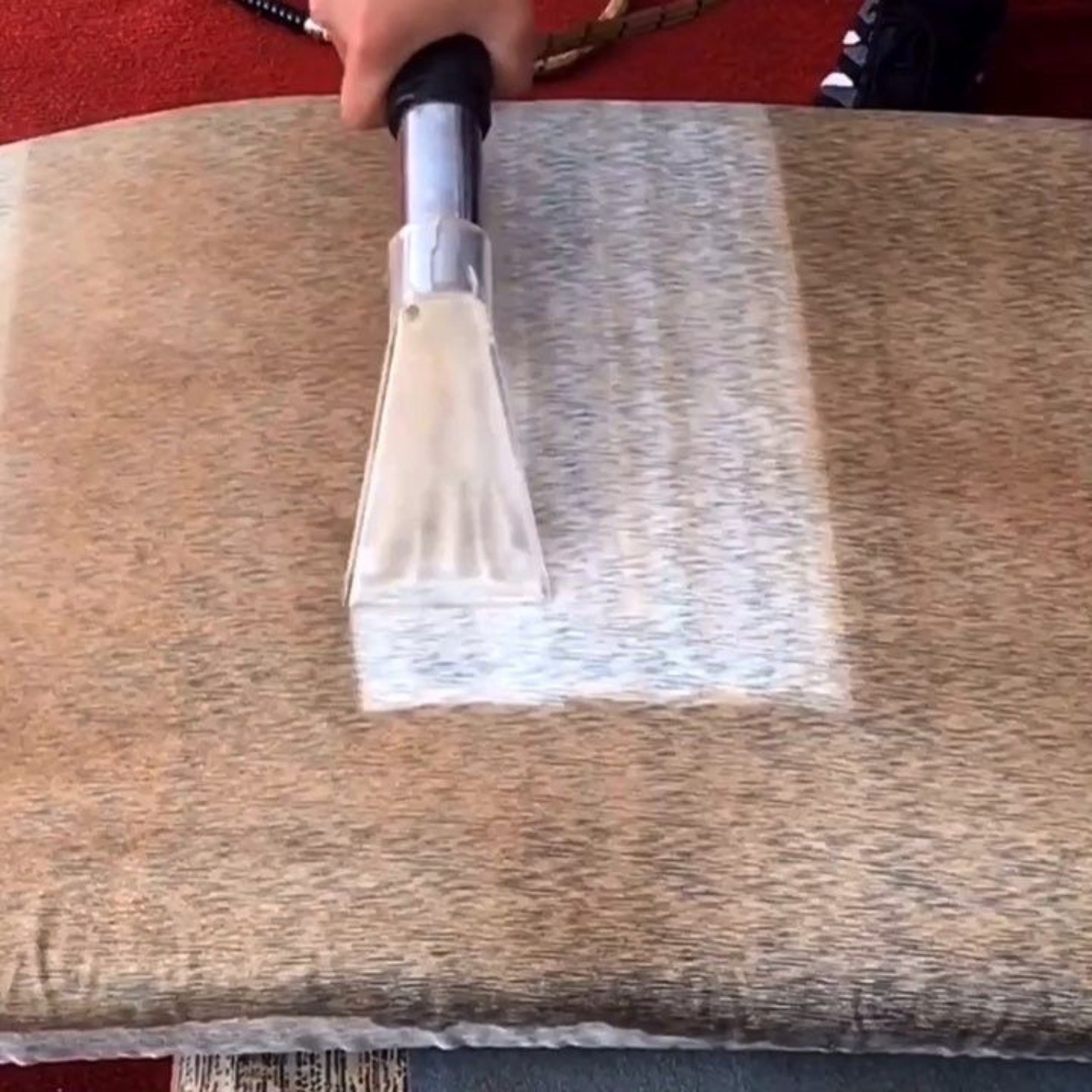 Extractor wand removing soil from upholstery or rug
